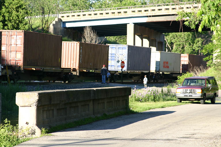 Bad father
Well, while watching a CP train head east past Jenison, this man finds it to be a good idea to teach his kids the joy of standing next to a moving freight train. At least one kid had enough sense to back off. 05/26/04 
