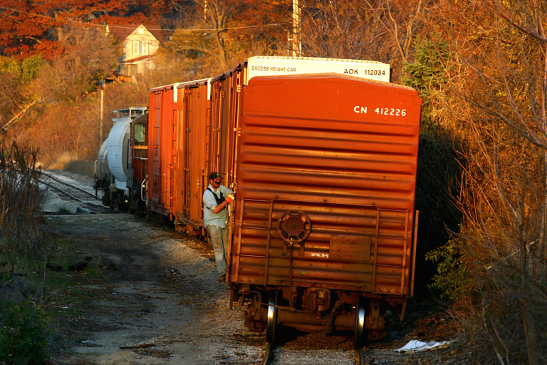 MMRR 179
Waited for a while at the street entrance to the Lake Express ferry, MMRR ran around its cars and got inbetween it's boxcars and the hopper and tanker.  The conductor is seen here riding their train towards Sappi.  Glad they hurried up and got over here right before the sunlight was gone.  11/11/05
