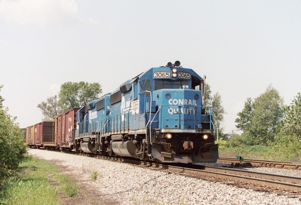 Conrail GP40-2 #3065
The familiar all-blue power for NS local train B-1-G rounds the curve at the View Crossovers, near West Botsford, with their train from Niles, Dowagiac, and Lawton. Some days, there is so much switching work that must be done on a Tuesday or Thursday that they die on hours in Dowagiac, then the crew is called the next morning to bring the train back to Kalamazoo. This was one such day, as they take their lunch hour train back into the yard. Conrail GP40-2s 3065 and 3066 are common on this train. Sept 2006.
Keywords: Conrail Quality CR 3065 3066 GP40-2 View Crossover Kalamazoo B-1-G B1G West Botsford