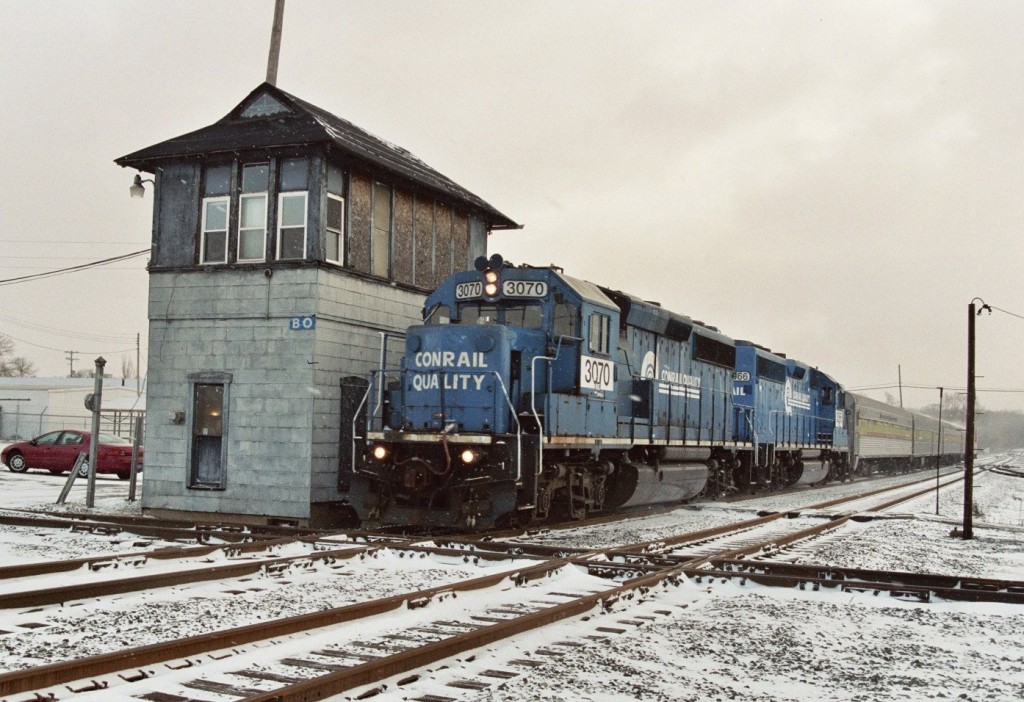 Conrail GP40-2 #3070 with the Artrain
Conrail GP40-2s #3070 and #3066 have a special charge this snowy Wednesday morning: Deliver the Artrain from Kalamazoo to Dowagiac Station where it will be on display during the upcoming weekend.  They are using local symbol B1G for this train, which is comprised of four passenger cars and a waycar (caboose in old NYC-talk) on the rear.  The train is shown accellerating past BO Tower in Kalamazoo on February 17, 2006.
Keywords: Conrail CR NS GP40-2 3070 3066 BO Tower interlocking junction diamond B1G B-1-G Artrain Art Dowagiac Kalamazoo waycar caboose