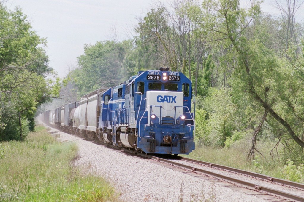 GMTX GP38-2 #2675
Northbound GLC Osmer Turn at Five Mile Road, south of Whitmore Lake, MI.  They have a healthy 37 cars of northbound freight from the interchange with the Ann Arbor Railroad.  The newly painted GLC power nicely matches the two GMTX GP38-2 rentals currently working on GLC freights.  June 22, 2009.
Keywords: Great Lakes Central GLC GMTX GP38-2 2675 Osmer Whitmore Lake