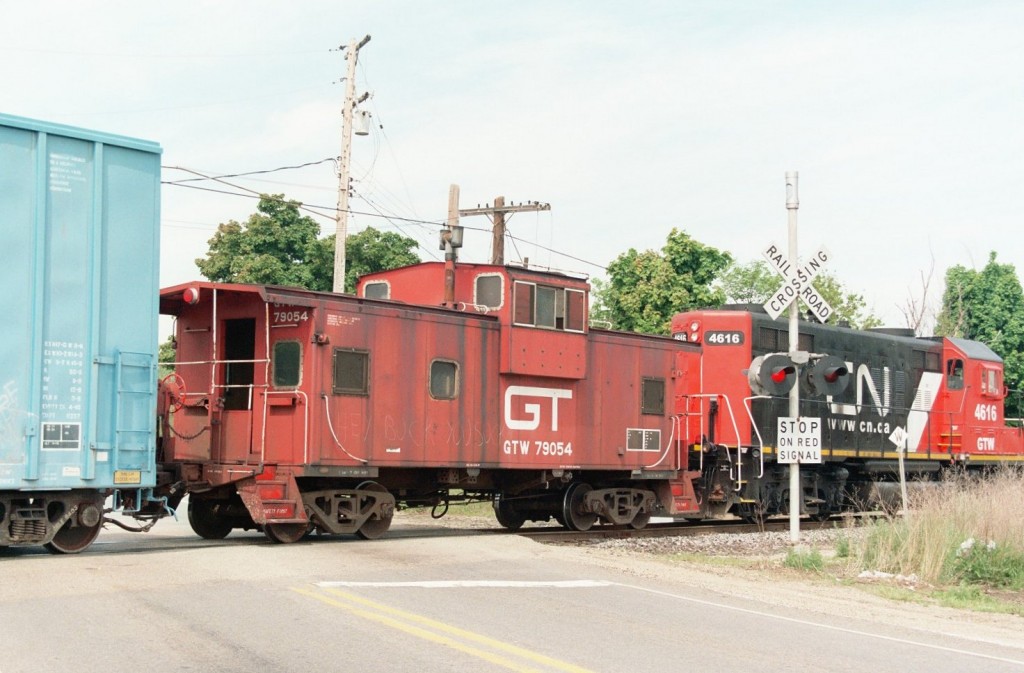 GTW Caboose #79054
CN921, the Kalamazoo turn from Battle Creek, is shown procceding northbound at Kilgore Road.  They always have a caboose in tow to lead a backup move over several road crossings in Kalamazoo.  For years, it was GTW Wide Vision #79046, but in the Spring of 2007, it was substituted for sister #79054.  The classic red 79054 is shown with recently repainted CN GP9R #4616 (also ex GTW) and their train near Kilgore Yard.  May 11, 2007
Keywords: Grand Trunk Western GT GTW Wide Vision caboose 79054 CN 921 GP9 4616 Kalamazoo crossbuck crossing