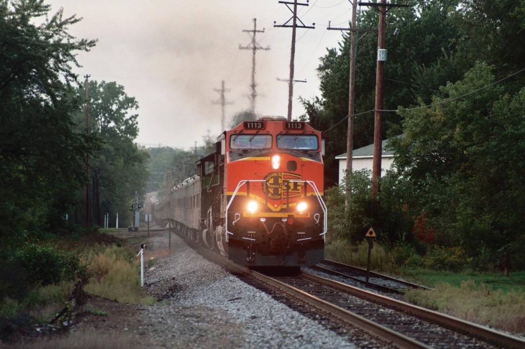 BNSF C44-9W #1113
NS 048, the Blue Unit of Barnum and Bailey's Circus Train, approaches the Vine Street crossing and semaphore in Kalamazoo shortly after 8 o'clock in the morning on September 11th, 2007. The train, powered by BNSF Heritage I #1113 (with changed out Heritage II front door), and BN green #9237, is slowing as they approach the BO Tower and diamonds, and are bound for Hughart Yard in Grand Rapids.  The 60-car train stretches up the hill and around the corner in this zoomed view.  The triangle with dot sign is to indicate a flanger to raise the blade for the switch ahead.  
Keywords: Barnum Bailey Circus Ringling Kalamazoo NS 048 NS048 RBBX BNSF 1113 9237 BN flange sign triangle Vine