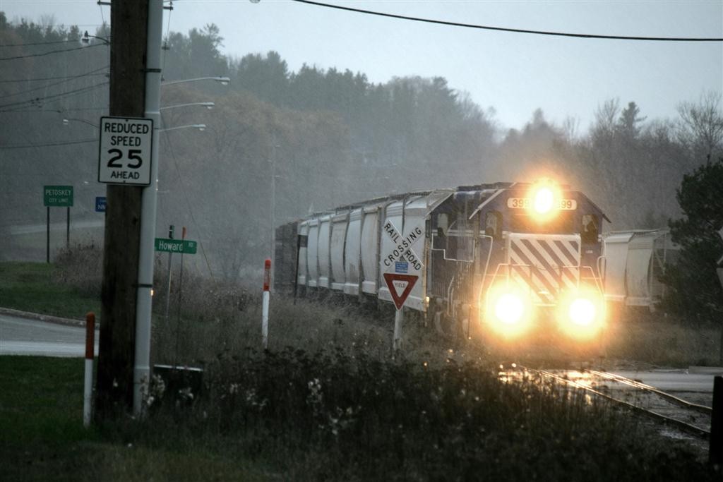 19 November 2015
With their loads delivered and empty cars together, the 399-398 are starting their trip back to Cadillac with snow in the air as they cross Howard Street leaving Petoskey.
