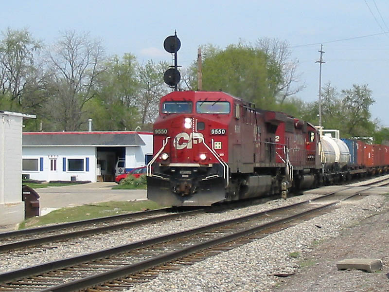 CP 9550
CP #9550 leads some mixed freight westwards in Grandville near a shopping plaza. 04/29/04 
