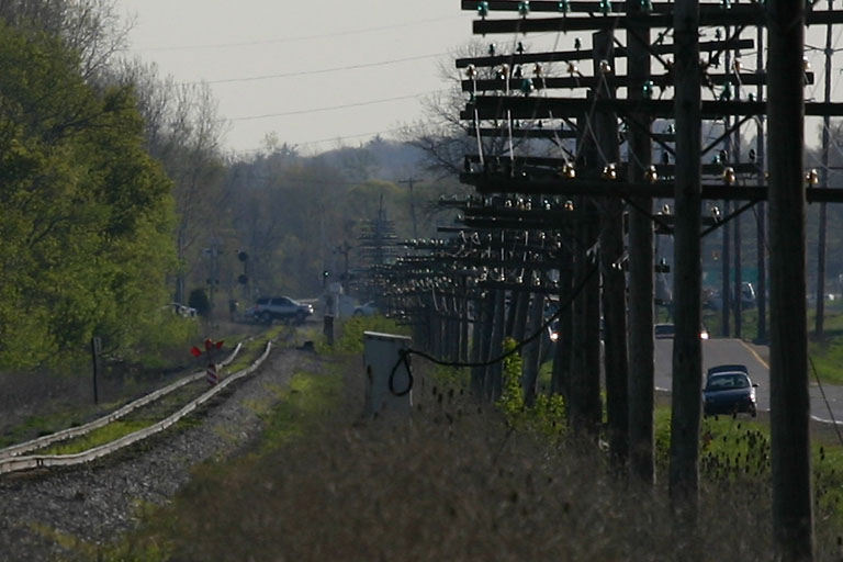 Q326 and obstruction.
Passed by this fella along Chicago Dr.  Q326 had just passed me, and I snapped this one... While leaving, I heard "Q326, stopped on the main, obstruction on the tracks."  Weasel in the weeds.......You can see the bridge at Sunrise Park and the signal for Port Sheldon in the distance.  04/28/06
