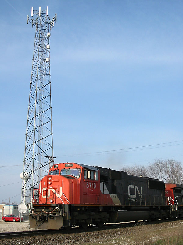 CN 5710
CN #5710 approaches west while passing by a cell phone tower in Schoolcraft. At least CN is making money by leasing the tower property rights here. 04/15/04 
