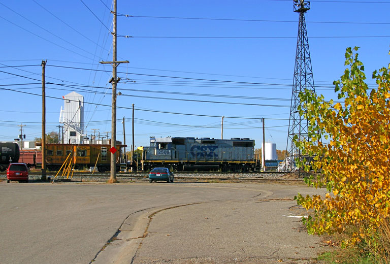 CSX 2509
CSX 2509 pulls a string 'o cars eastward through the yard, Chessie caboose following. Railfan's cars parked at the end of Judd St. - 2004
